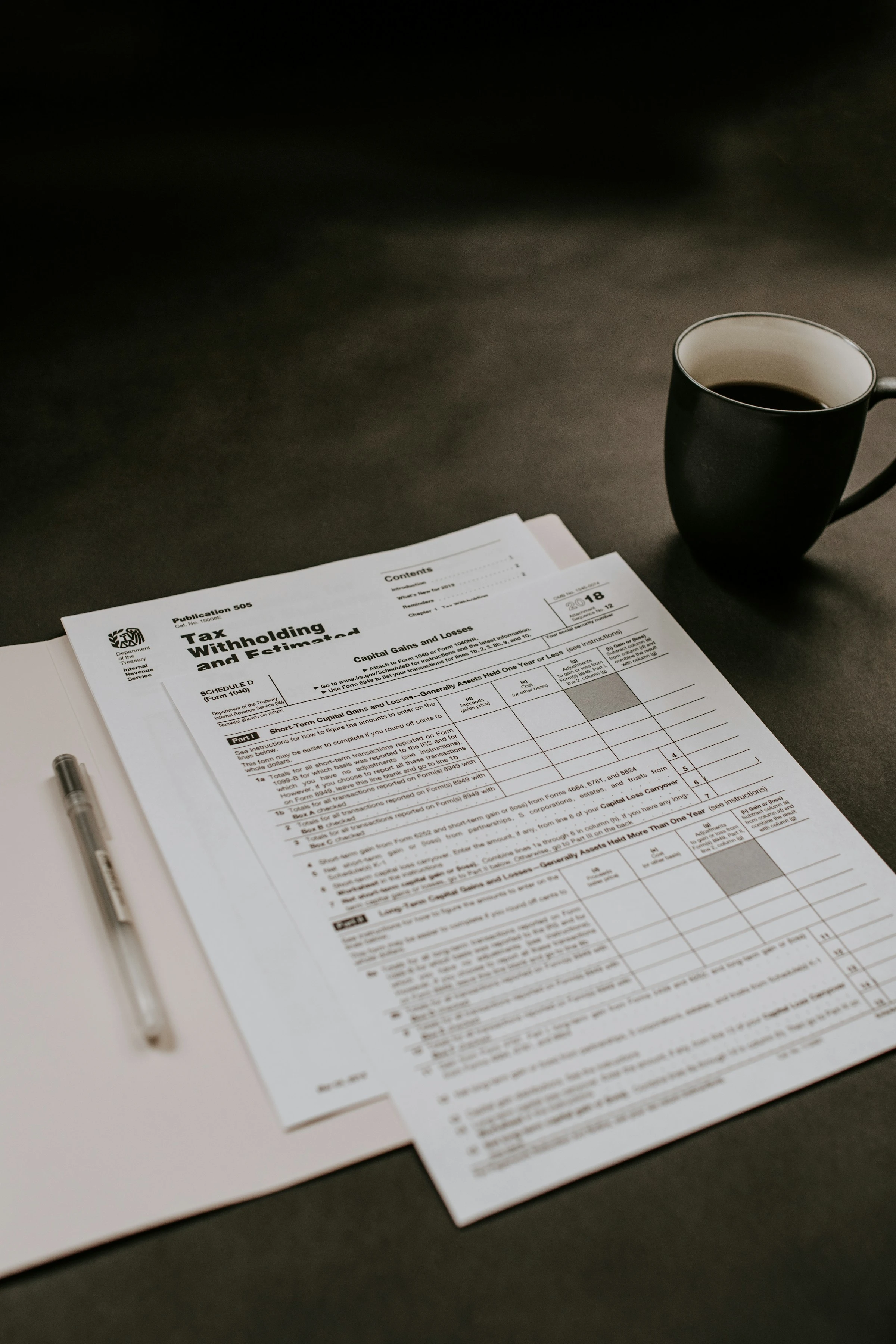 A coffee cup sitting on a table behind tax forms